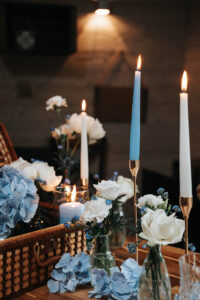 Bougies et fleurs blanches et bleues pour un centre de table de mariage couleurs tendances
