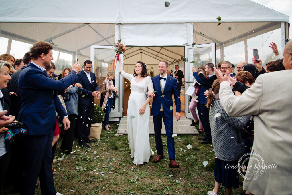 Plan B pour une cérémonie laïque, sortie de cérémonie, les mariés mains dans la mains, les invités applaudissent.