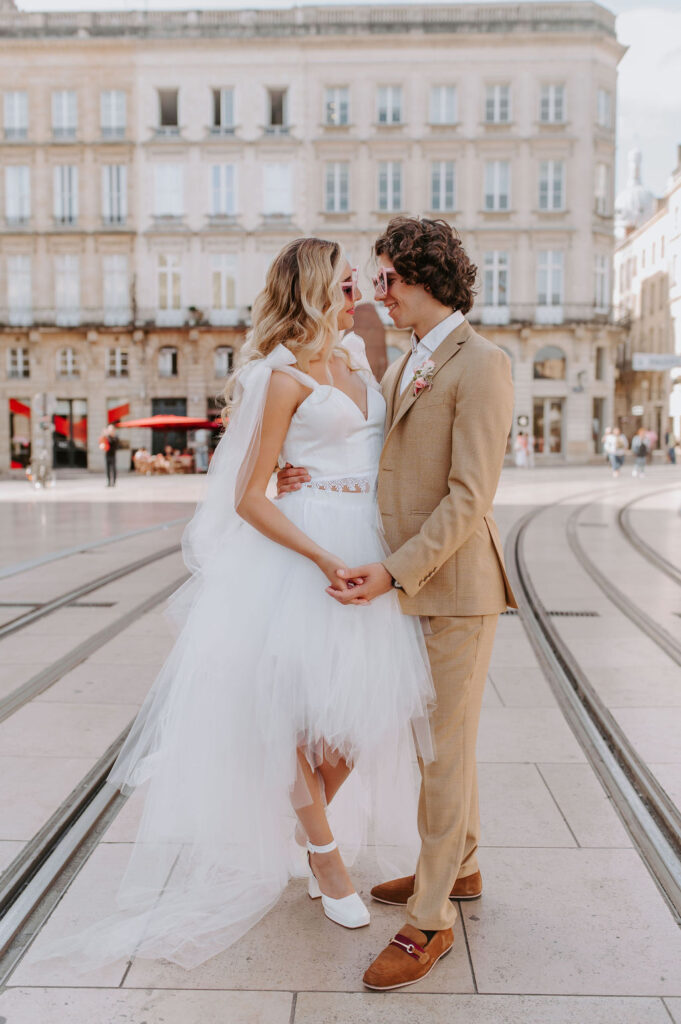 robe de mariée, costume beige, lunettes de soleil, boutonnière, tram, mariage urbain, mariage en ville