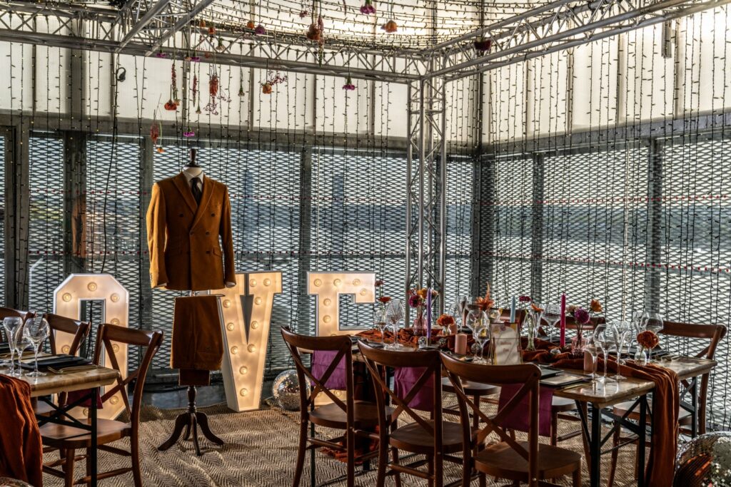 lettre lumineuse, love, love lumineux, cube lumineux, costume de marié, costume, terracotta, moutarde, table en bois, chaise en bois, fleurs, multicolore, fleurs multicolores, fleurs suspendues