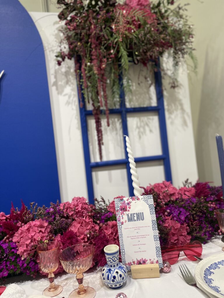 mariage grec, mariage bleu, blanc, rose, bougie, menu grec, vaisselle vintage, verre rose, lunette de soleil, coeur, bougies, hortensia, hortensia rose, stand salon, salon