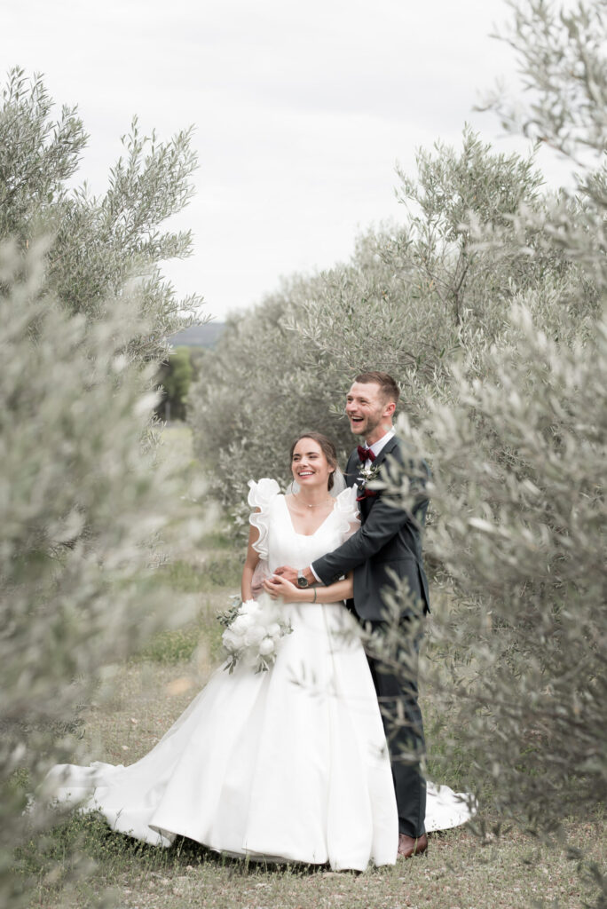 mariés enlacés entre des arbres