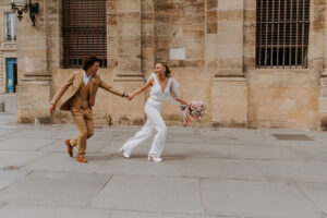 urbain, mariage en ville, ceremonie civile, bouquet rose, fleurs, mariée en combinaison, combinaison, costume beige, mairie, pierre,