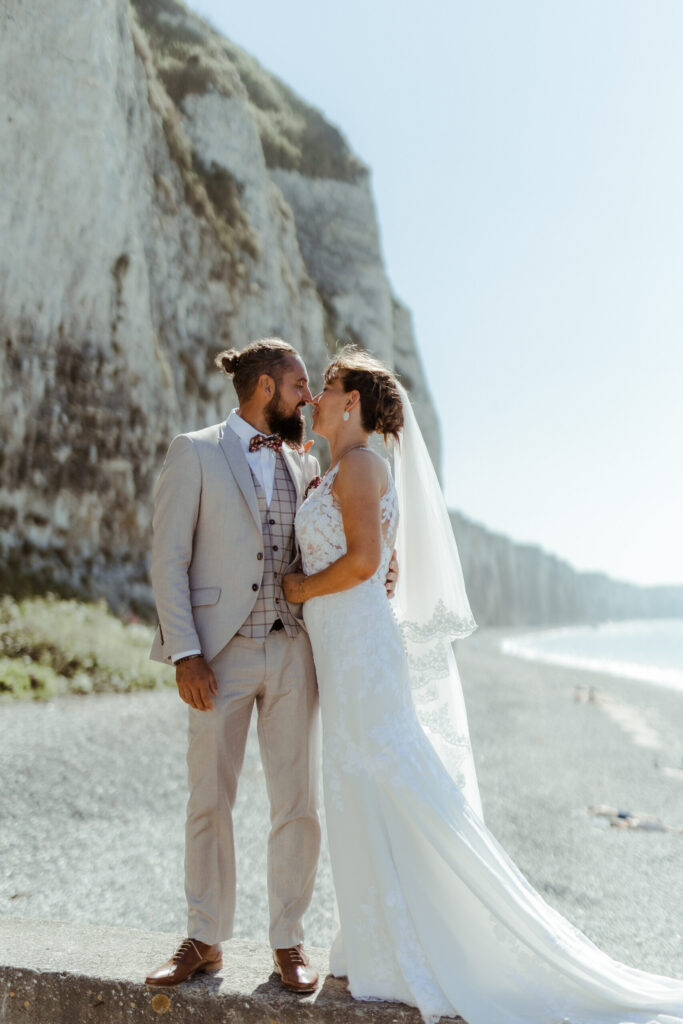 Mariage de Jessica et romain, photo de couple, voile moderne, dentelle, costume, falaise, mer, plage, bisou