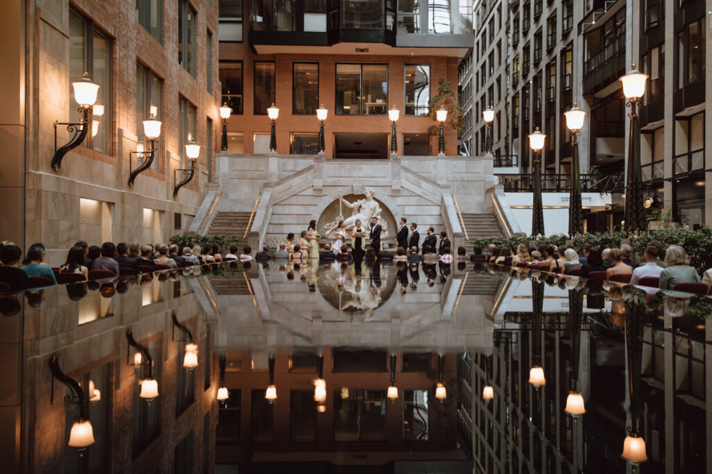 Cérémonie de mariage en cours au bout la fontaine dans le Centre de commerce mondial de Montréal, Mariage en intérieur illuminé, Mariage en ville
