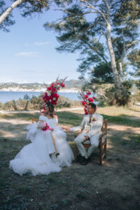 Mariés en cérémonie laïque, demi arche, couleur rose orange, vue mer