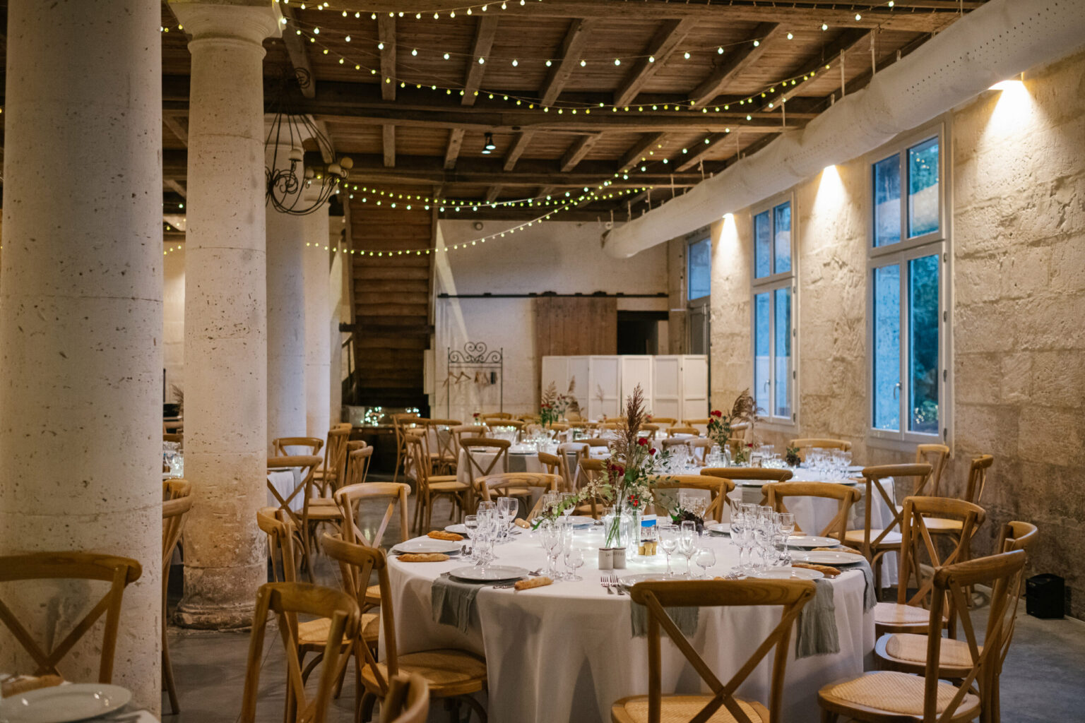 Domaine de Belisle, salle de réception, décoration salle, wedding designer, bougie, lumière, ampoule, table, chaise, beau, poutre, mur, pierre